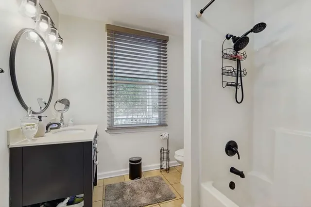 A clean tub-and-shower bathroom at Ola's Oasis, a Savannah, GA vacation rental.