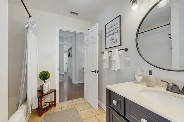 A round mirror and vanity offer a comfortable space to get ready at Ola's Oasis in Savannah, GA.