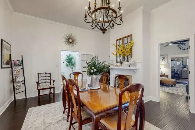 Dining table set beneath a sunburst mirror and fireplace mantel at Ola's Oasis, a Savannah, GA vacation rental.