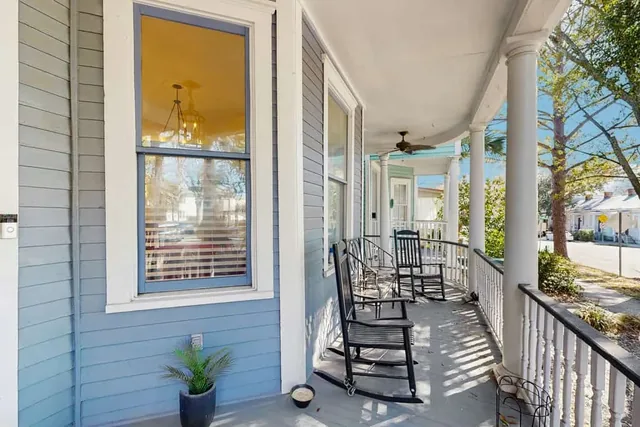 Classic rocking chairs on the shaded front porch of Ola's Oasis, a historic Savannah, GA vacation rental home.