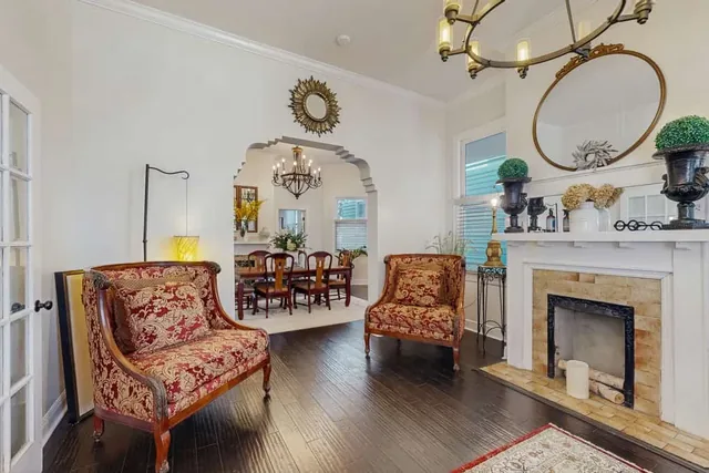Antique armchairs beside a warm tiled fireplace make a quiet corner of the living room at Ola's Oasis, a Savannah, GA vacation rental.